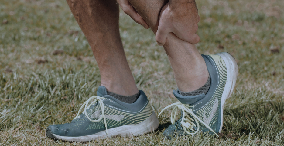 main on a hike holding his sprained ankle