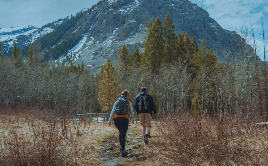 couple hiking safely together towards a mountain